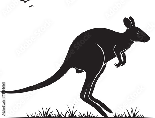 Silhouette of a jumping kangaroo in silhouette with small birds flying above grass