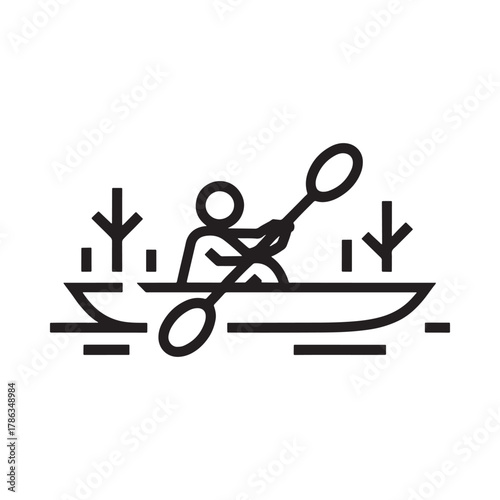 Person kayaking through reeds on water