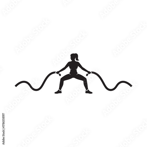 Silhouette of a woman performing battle rope exercises
