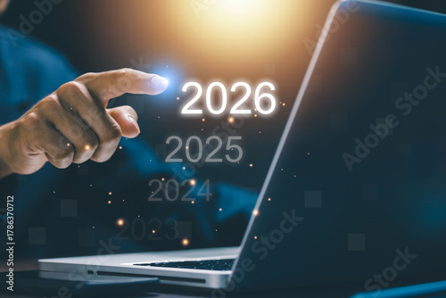 Businessman touching digital interface showing 2026 with previous years fading. Concept of future vision, innovation, and technology progress for business transformation and planning.