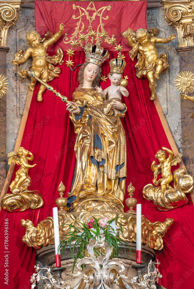Naklejka premium SALZBURG, AUSTRIA - SEPTEMBER 6, 2025: The carved baroque polychrome statue of Madonna on the main altar in the church Pfarrkirche Mülln by Jakob Kaschauer (1453)
