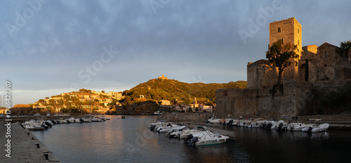 Fototapeta Naklejka Na Ścianę i Meble -  Sunset view of colourful Collioure, narrow streets and yellow, pink, orange houses, summer vacation destination town with historical buidings and beaches, Pyrenees-Orientales, France