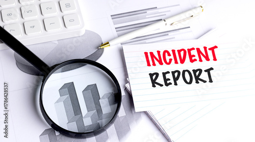 Incident report message on lined card with magnifying glass, pen, charts and calculator symbolizing workplace