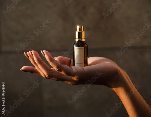 hand holding bottle of perfume