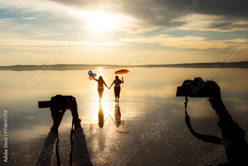 Tuz Lake, located in Ankara province of Türkiye, has a wonderful view at sunset. Visitors walking in the shallow waters of the lake watch the sunset by taking photos or taking pictures.