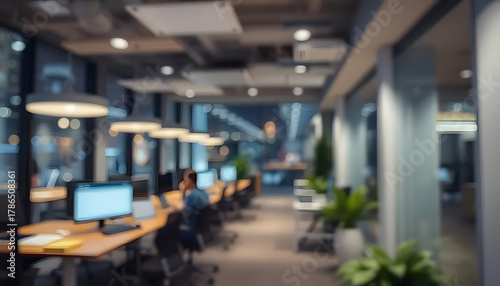 Blurred view of an open office space with desks and plants