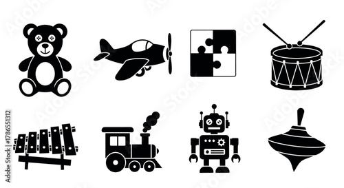 Black silhouette icons of various classic children's toys including a teddy bear, airplane, puzzle, drum, xylophone, train, robot, and spinning top.
