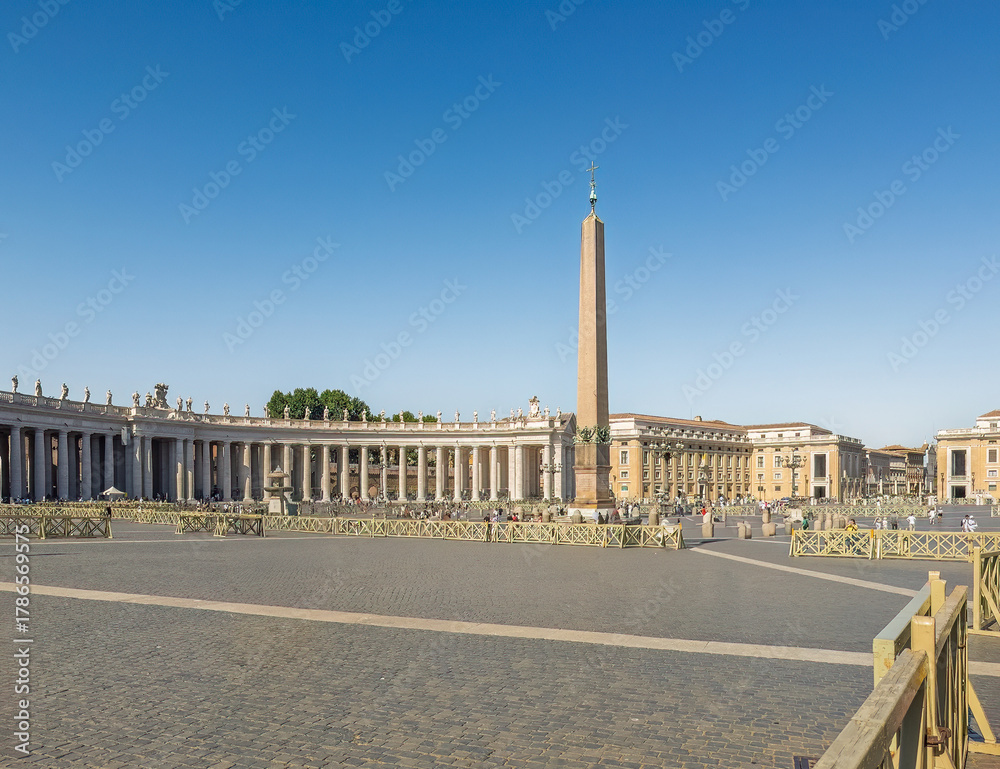 Naklejka premium Vatican City, Rome, Italy - July 16, 2024: Saint Peter Square, Piazza San Pietro. Vatican obelisk and the north Tuscan colonnades under blue sky. To the right, looking into Via della Conciliazione.