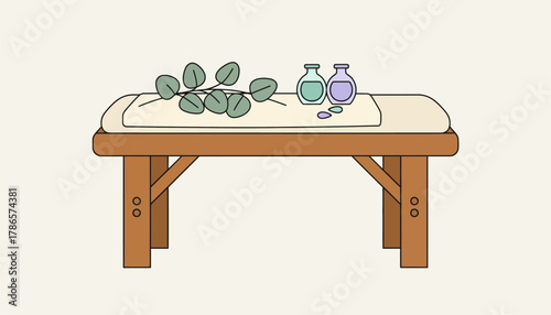 A wooden massage table set with fresh eucalyptus branches and calming oils ready for a relaxing treatment.