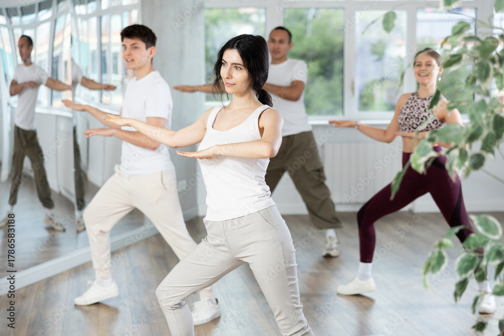 Naklejka premium Smiling people practicing vigorous lindy hop movements in dance class