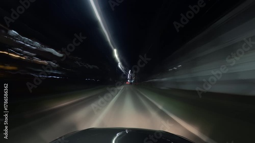 Dynamic night city time-lapse filmed from a moving car, showing bright light trails from traffic and streetlights. Perfect for urban, travel, or nightlife themed video projects.