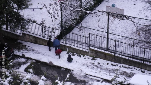 Father and kids trying to make a snowman