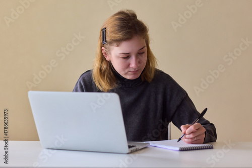 Determined individual with cerebral palsy immersed in educational activities indoors, Courageous woman with cerebral palsy concentrates on studying at home with dedication