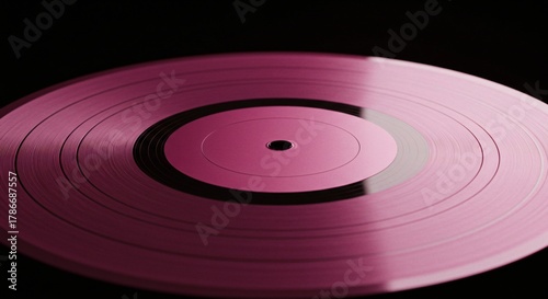 a close up of a pink record on a black background