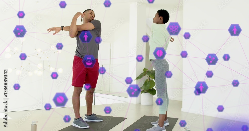 Naklejka premium Stretching exercise partners extending arms on mats at home in sportswear with purple AR icons