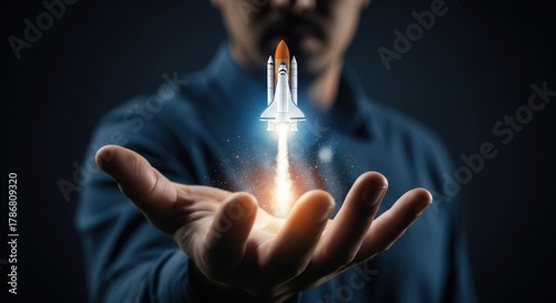 Fototapeta Naklejka Na Ścianę i Meble -  Man holding a glowing rocket ship launching from his open palm