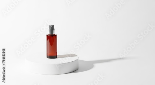 Amber bottle with spray nozzle on white pedestal against white backdrop