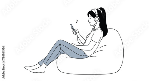 Young woman happily listening to music on headphones while scrolling through phone content, relaxing on a beanbag chair