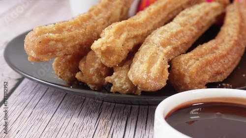 Close-up of a plate with churros and liquid chocolate to accompany them
