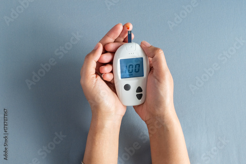 Woman's hands checking diabetes and hyperglycemia with digital blood sugar meter. Healthcare and medical concept	