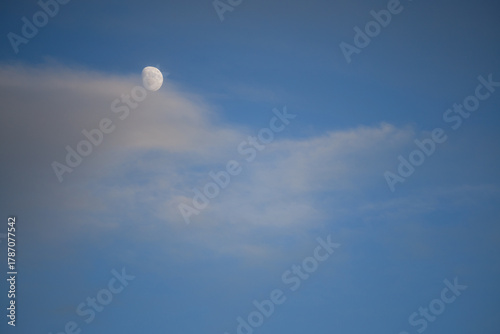 Moon and clouds in a blue sky at dusk