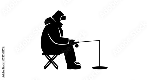 Lone ice fisherman patiently waiting for a bite on a frozen lake