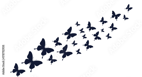 A swarm of dark blue butterflies flies in a diagonal line from the bottom left to the top right of the image.