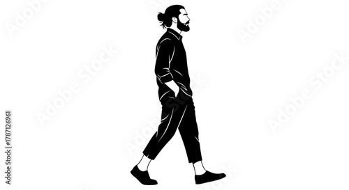 Stylish man with beard and bun walks confidently in modern attire
