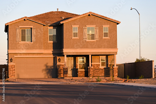 Newly constructed two-story single-family home with attached garage and stone-accent facade, representing unoccupied housing inventory in a developing suburban subdivision