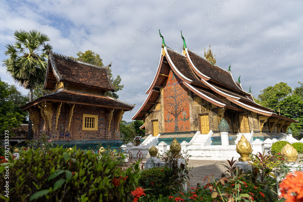 Fototapeta premium An important Buddhist monastery and symbol of the UNESCO World Heritage town of Luang Prabang, featuring the distinctive low-sweeping tiered roofs.