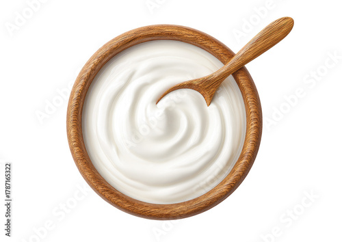 Overhead view of a wooden bowl filled with swirled white dairy product, accompanied by spoon