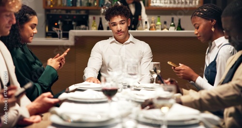 Fotografía Man, annoyed and group at restaurant with phone addiction, social isolation and bored at dinner