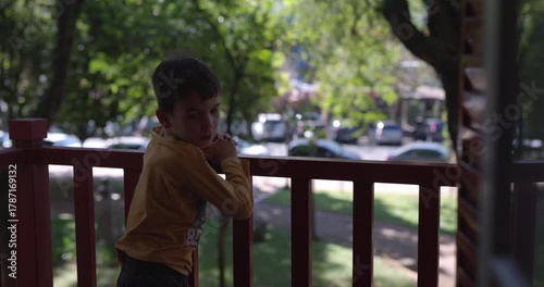boy on city balcony comes inside house - urban child