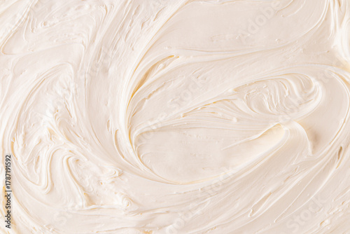 An example of the chic texture of buttercream. A beautiful pattern of delicate waves of beige pastry cream. top view. A copy space. selective focus