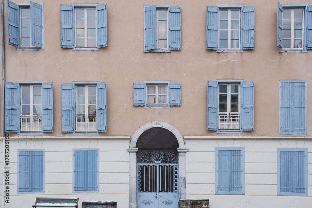 Fototapeta premium French architecture creating symmetrical facade with blue shutters