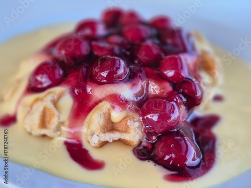 Close-up of a fresh waffle with hot cherries and blurred background 