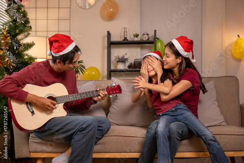 Family celebrating christmas surprising happy girl with music