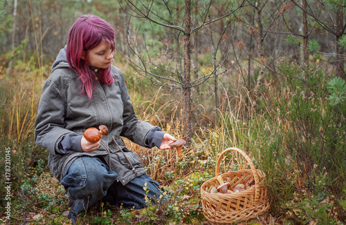 Young girl mushroom picking in autumn forest