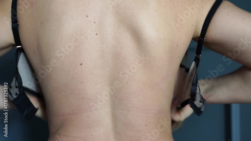 Bra, unfastening, woman unhooking her black lace bra from the back, preparing for an intimate moment