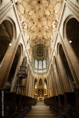 Kutná Hora, Czech Republic – August 8, 2025: Central nave of St. Barbara’s Cathedral with wooden pews leading to ornate Baroque altar and Gothic vaulted ceiling in Kutná Hora