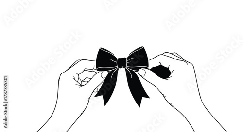 Hands carefully tie a classic black satin bow, symbolizing elegance and celebration.