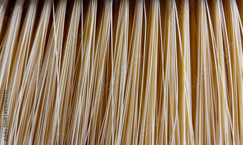 Close-up of household broom bristles made from synthetic beige fibers with vertical pattern, perfect for background, cleaning concept, or domestic product texture.