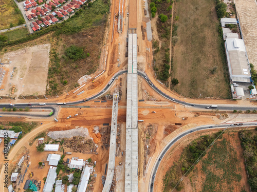 The construction site before the construction of the concrete bridge over the intersection by crane workers, tractors, and backhoes