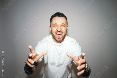 Laughing man reaching hands forward energetically.