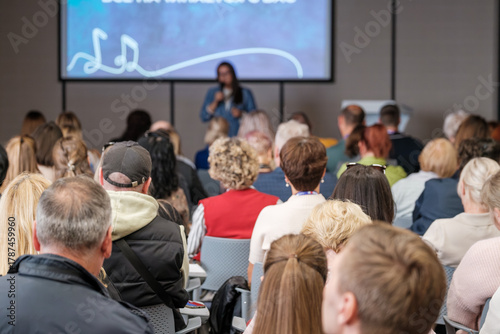 Wallpaper Mural Crowd sits in conference room listening to speaker with large screen presentation in back Torontodigital.ca