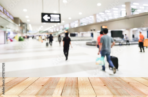 Wooden floor blank space with Defocus Blurry passengers people of crowd anonymous walking at the airport. scene of airport with passengers activity. Terminal Departure Check-in at airport.