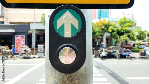 Manual button for pedestrian crossing traffic lights in Indonesia by pressing with blurred background of road traffic