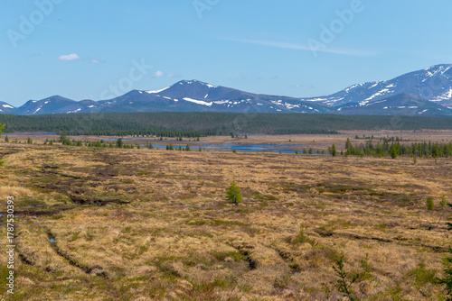 Russia, Magadan Region. Nature of Siberia and the Russian Far East. A marshy plain in the tundra against the backdrop of mountains in the area of Lake Malyk