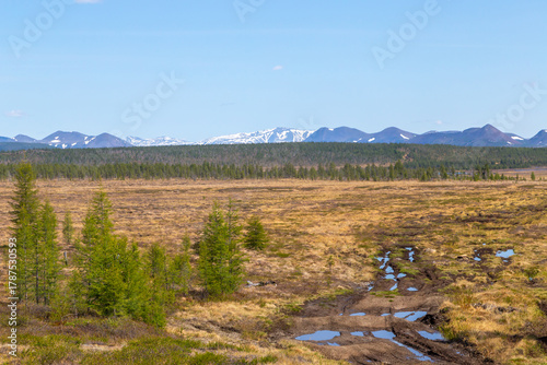 Russia, Magadan Region. Nature of Siberia and the Russian Far East. A marshy plain in the tundra against the backdrop of mountains in the area of Lake Malyk