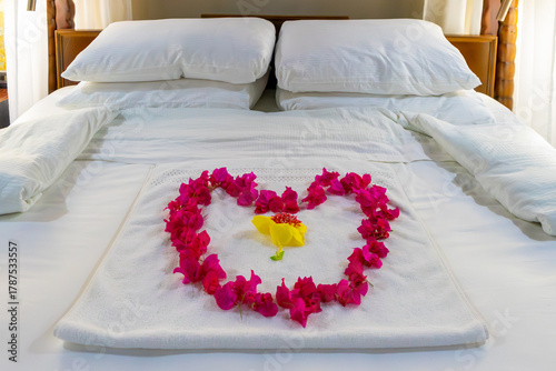 Принти на полотні A luxurious four-poster bed adorned with a heart of bougainvillea petals welcome